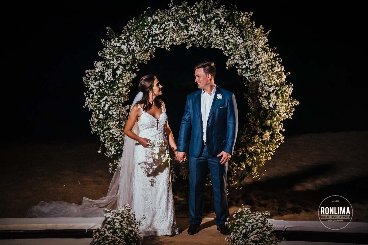 Ensaio dos noivos durante o casamento pé na areia